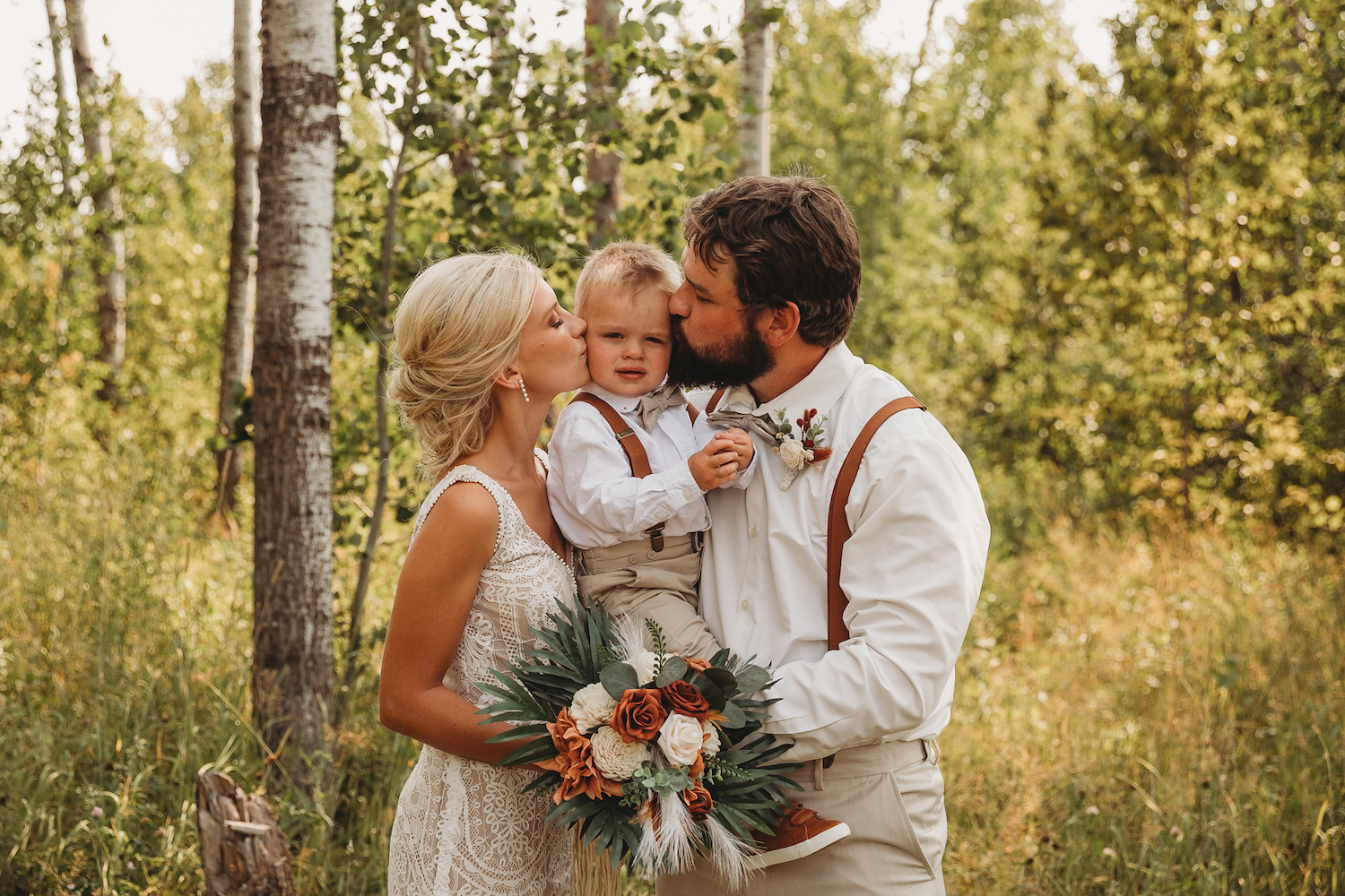 Rylie on the left kissing her son Knox's cheek with her husband, Aaron, kissing Knox's cheek on the right on their wedding day.